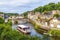 panoramic view of old stone bridge and historical medieval houses reflecting in La Rance river in Dinan town