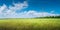 Panoramic view over beautiful green farm landscape with light and shadow waves in Germany with clouds in sky, wind turbines to