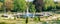 Panoramic view over garden, pools, flowers, old statues, fountains and many tourists in the city park of Potsdam, a German town of