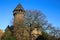 Panoramic view over moat on medieval water castle and defensive tower with bare trees in winter against blue sky - Krefeld Linn