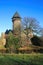 Panoramic view over moat on medieval water castle and defensive tower with bare trees in winter against blue sky - Krefeld Linn