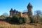 Panoramic view over moat on medieval water castle and defensive tower with bare trees in winter against blue sky - Krefeld Linn