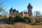 Panoramic view over moat on medieval water castle and defensive tower with bare trees in winter against blue sky - Krefeld Linn