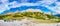 Panoramic view over touristic parking lot and magical granite Dolomite peaks and alpine forests of Pizes da Cir, Passo Gardena,