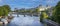 Panoramic view of the Pont des Arts in Paris with the Louvre museum behind the bridge over the Seine river that divides Paris in