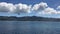 Panoramic view from port of Portoferraio village of green coast of Elba island and beautiful white clouds and seagulls , Livorno,