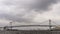 Panoramic view of the Rainbow Bridge in Tokyo, Japan, on a rainy day with cloudy sky