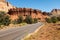 A panoramic view of the red, rugged and barren Canyonlands National Park, Utah with a dirt road weaving its way through