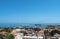 Panoramic view of rhodes town with buildings of the city and old walls around the harbor with ships and boats next to a blue