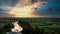 Panoramic view of river between fields during sundown