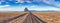 Panoramic View of a road in a dry desert with Shiprock