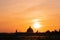 Panoramic view of the roofs, towers, domes of cathedrals silhouetted against sunset light.