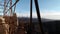 Panoramic view through rusty scaffolding of restored Hrusov castle, eastern part, to surrounding forested hills.
