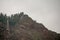 Panoramic view of sheer volcanic cliff rising above ocean.