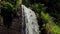 Panoramic view of small artificial waterfall in sunny spring day