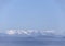 Panoramic view of snow covered Parnassus Mountains on a sunny day from the island of Evia, Greece