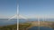 Panoramic view a source of clean energy, four wind turbines in a row and rotating blades on a summer evening.