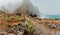 Panoramic view of stony hiking path to Ponta do Sol over amazing arid Aranhas valley with huge mountain peak and house