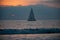 Panoramic view of sunset over ocean. Sailboat on the sea. Sailing boat floating on the blue ocean during sunrise with