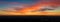 Panoramic view of sunset scene with mountains in background