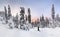 Panoramic view of sunset in the snowy forest, with one skier on the ski run