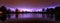 Panoramic view of thunderstorm lightning strikes reflecting in water surface calm lake purple light night