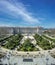 Panoramic view of tourists gathering around Royal Palace (Palacio Real), Plaza de Oriente, Lepanto Gardens (Jardines de Lepanto) a