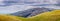 Panoramic view towards Mission Peak on a cloudy spring day; a herd of cattle visible grazing on the hillside; South San Francisco