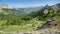 Panoramic view towards the Northern side of Izoard Pass, with a winding road, pine tree forests and mountain range