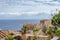 Panoramic View of Traditional House Rooftops in Medieval Castle Town of Monemvasia. Deep Blue Sea and Cloudy Sky in the Horizon