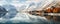 panoramic view of a tranquil lake surrounded by towering mountains, with the reflection of the snow-capped peaks panorama