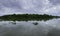 Panoramic view of trees and clouds reflecting on glassy lake