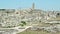 Panoramic view of typical stones Sassi di Matera and church of Matera under blue sky. Basilicata, Italy, zoom out camera