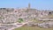 Panoramic view of typical stones Sassi di Matera and church of Matera under blue sky. Basilicata, Italy, zoom out camera