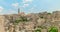 Panoramic view of typical stones Sassi di Matera and church of Matera under blue sky with clouds, time lapse effect, movement