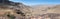 Panoramic view of a unpaved road winding through the mountains