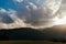 Panoramic view of a valley surrounded by hills at sunset with the sun