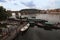 Panoramic view of Vltava river with Charles Bridge and many historical buildings. Small pier with different boats for tourist trip