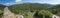 Panoramic view from white limestone tower Perda Liana, impressive rock boulders, green forest hill and mountain