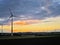 Panoramic view of wind farm or wind park on sundown, with high wind turbines for generation electricity with copy space