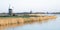 Panoramic view of windmills along a lake in Holland