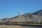 Panoramic view of windmills and railroad with clear blue sky and mountains