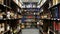 Panoramic view of wine shop interior. Various wine bottles sale on wooden shelves in supermarket