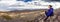 Panoramic view of woman hiker on a rocky mountain. Spring hike t
