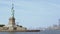Panoramic view of world famous Statue of Liberty with crowd of tourists and New York City in background, view from water