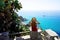 Panoramic view of young woman sitting on wall in Capo Vaticano enjoying lookout of the Coast of the Gods, Calabria, Italy