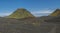 Panoramic volcanic landscape of green Hattafell and Storasula mountain with hikers on path in lava desert on famous