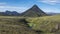 Panoramic volcanic landscape of green Storasula mountain with lush moss and blue creek water between Emstrur and