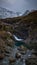 Panoramic waterfall and snow-capped mountains. loose stones in the foreground and turquoise water - Fairy Pools - Skye Island -