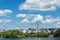 Panoramic waterfront residential complex grassy lawn under cloudy blue sky